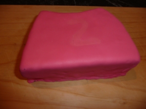 Peppa's Dress. Wrap the icing around the cake and trim with a sharp knife